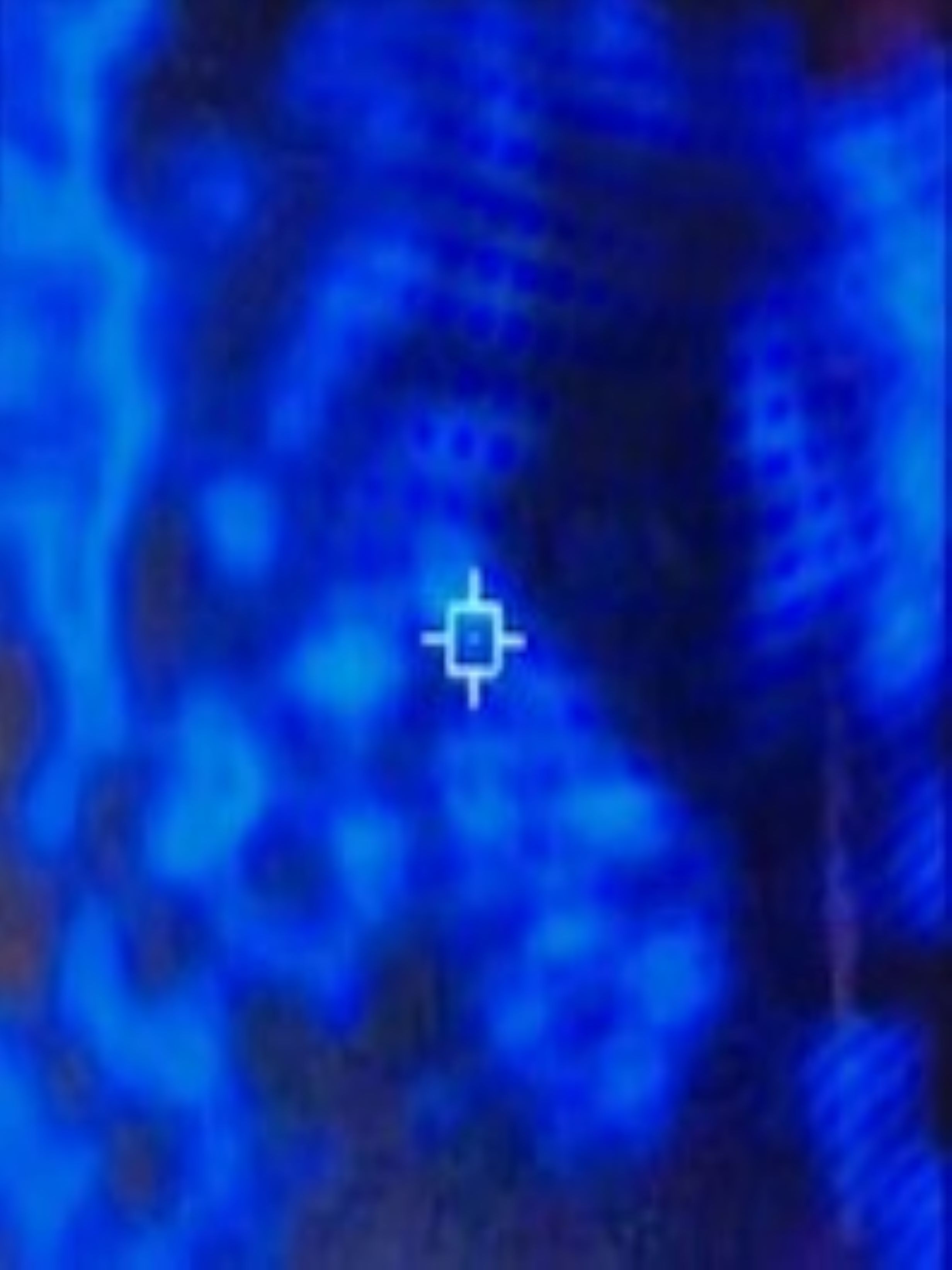 Thermal imaging footage of a mottled blue background with a targeting reticle centered on a faint dark patch in the upper frame
